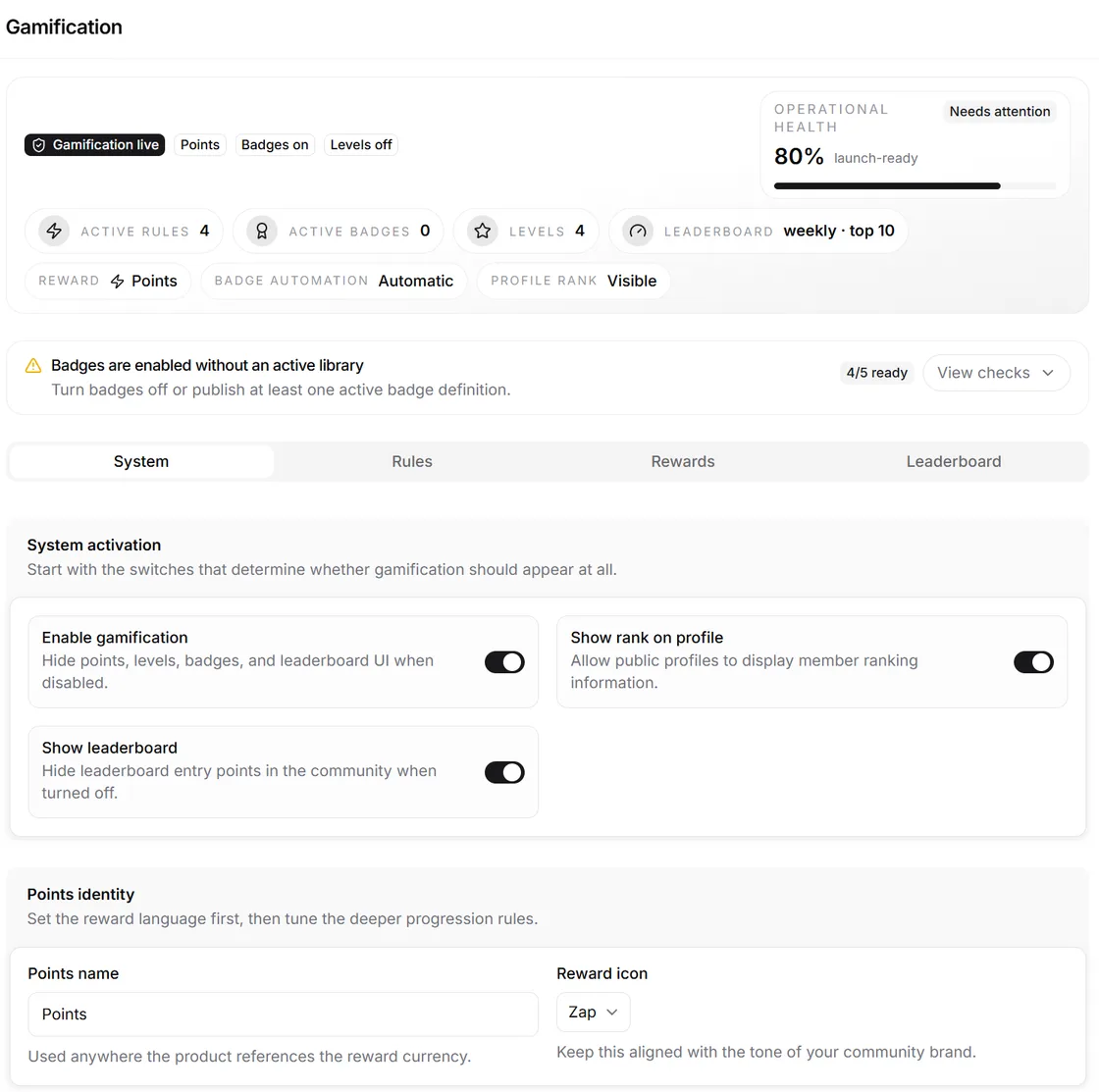 La pantalla de ajustes de gamificación: etiquetas de estado que indican si la gamificación, los puntos, las insignias y los niveles están activos, contadores de reglas activas, insignias activas, niveles y ventana de la clasificación, una comprobación que avisa de que las insignias están activadas sin una biblioteca publicada, y pestañas de sistema, reglas, recompensas y clasificación sobre interruptores para activar la gamificación, mostrar el rango en los perfiles y mostrar la clasificación, más un campo para renombrar la moneda de puntos.